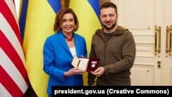 Președintele Camerei Reprezentanților a Statelor Unite, Nancy Pelosi, primind decorația „Prințesa Olga” de la președintele Ucrainei, Volodomir Zelenski. Nancy Pelosi a mers la Kiev pe 30 aprilie 2022 și a vizitat inclusiv zone distruse de bombardamentele rusești.