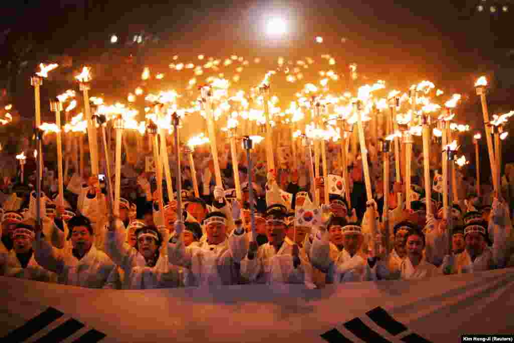 Participants carrying torches pose during a reenactment of the March First Independence Movement against Japanese colonial rule in Cheonan, South Korea. (Reuters/Kim Hong-Ji)