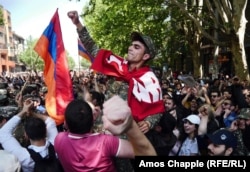 A soldier is carried through a crowd on the day Armenia’s prime minister resigned amid massive street protests. Photo by Amos Chapple/RFE/RL