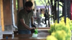 Armenia -- A waiter disinfects a table at a Yerevan cafe, May 4, 2020.