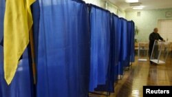 Hoping to do it all again? A member of the local electoral commission carries a ballot box at a polling station in Kyiv on October 27.