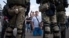 Люди розмовляють із білоруськими правоохоронцями поблизу місця, де протестувальник загинув 10 серпня під час мітингу після президентських виборів у Мінську, Білорусь, 11 серпня 2020 року.