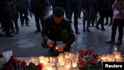 A man lights a candle during a memorial service for victims of a blast in the subway in St. Petersburg on April 3.