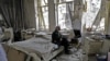 Mohammad Mohiedine Anis, 70, smokes his pipe as he sits in his destroyed bedroom listening to music on his vinyl player in Aleppo&#39;s formerly rebel-held Al-Shaar neighborhood. (AFP/Joseph Eid)