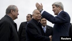 Өзбекстан президенті Ислам Каримов (ортада) АҚШ мемлекеттік хатшысы Джон Керриді (оң жақта) Самарқан әуежайында қарсы алып тұр. Өзбекстан, 1 қараша 2015 жыл.