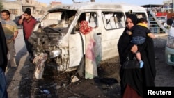 A woman walks near the site of a car-bomb attack in Baghdad's Sadr City on May 16. 