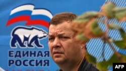 A man walks past an election poster for the United Russia party in central Moscow.