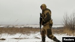 A separatist soldier walks in a field near the line of contact where a cease-fire is scheduled to take effect at midnight on December 24.
