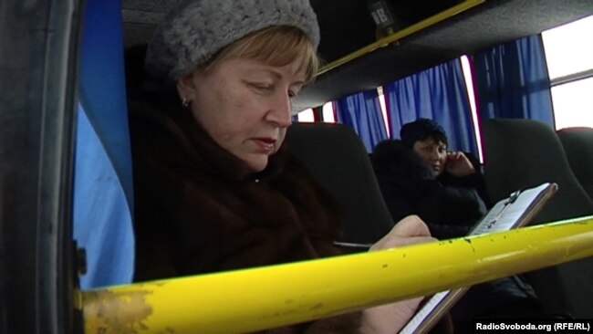 Жінка заповнює “документи”, щоб потрапити до Луганська