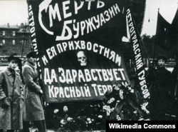 Червоний терор був поширеною практикою більшовиків. Ця світлина з Росії. Плакат з написом російською «Смерть буржуазії і її прихвостням. Хай живе червоний терор!». Петроград, 1918 рік