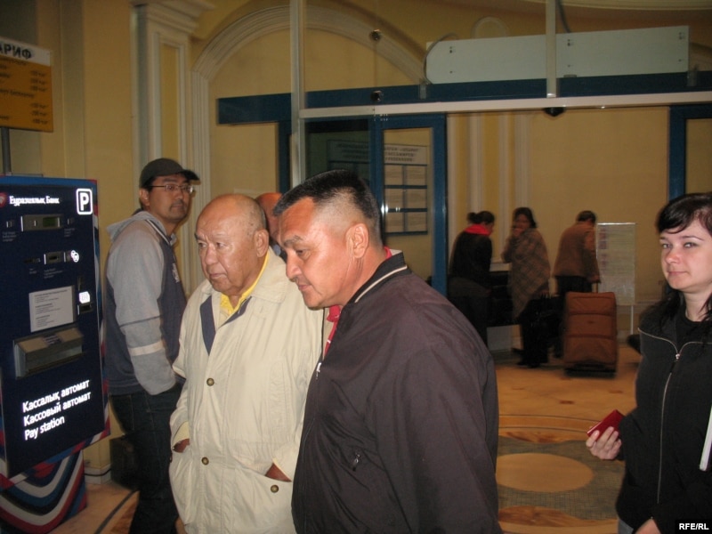 Мухтар Алиев в сопровождении встретившего его мужчины (слева) выходит из ВИП-зала аэропорта. Алматы, 4 октября 2009 года. 