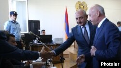 Armenia -- Karabakh President Bako Sahakian (C) and his predecessor Arkadi Ghukasian (R) shake hands with prosecutors during former Armenian President Robert Kocharian's trial in Yerevan, May 16, 2019.