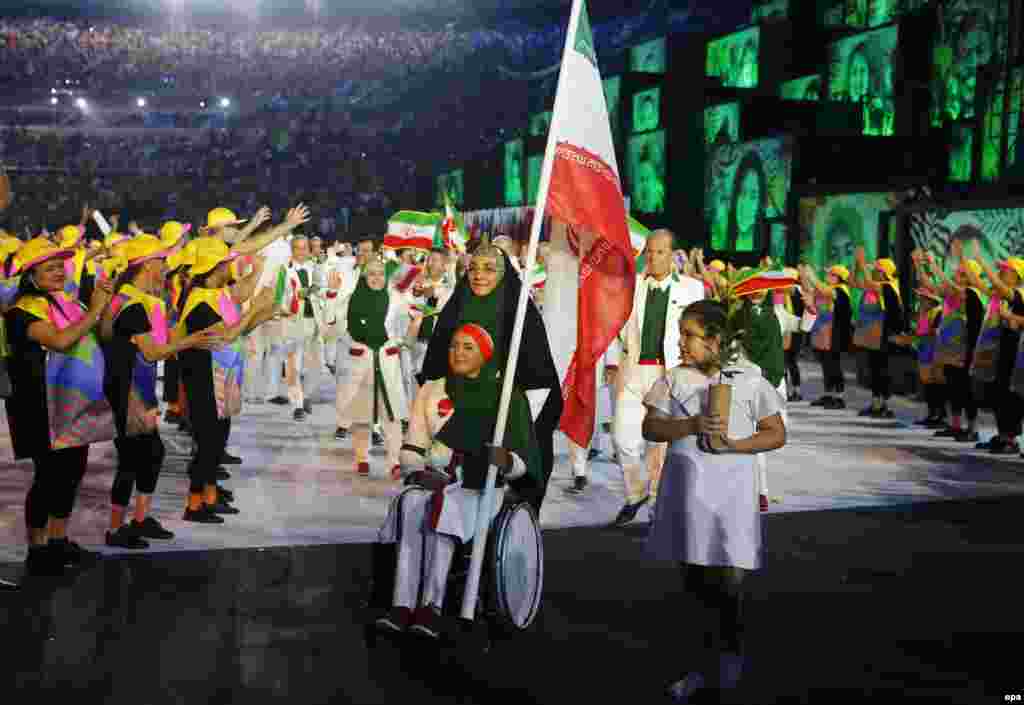 Zahra Nemati (center) of Iran leads her team into the stadium. Nemati, an archer, became Iran&#39;s first-ever female flag bearer. She will compete for Iran in both the Olympic and the Paralympic games next month.