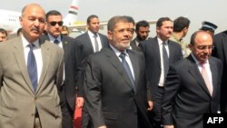 Egyptian President Muhammad Morsi (center) is flanked by Pakistani and Egyptian officials upon his arrival at the Chaklala military air base in Rawalpindi on March 18. 