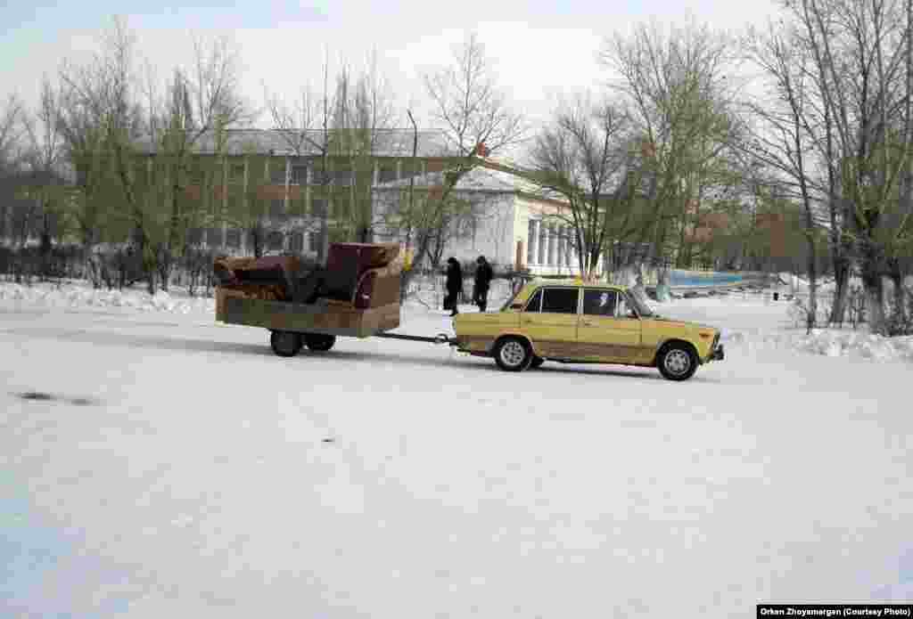Машина, везущая на прицепе груз.