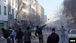 Protesters clash with riot police during a demonstration in Tehran on February 14.