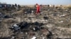 Член спасательной команды среди обломков украинского самолета МАУ на месте авиакатастрофы