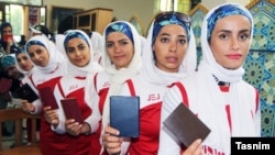 Women wait in line to cast their votes in parliamentary elections in Tehran on February 26.