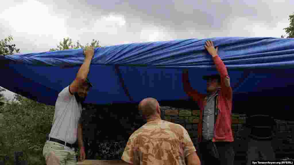Активисты накрывают столы брезентом на случай дождя