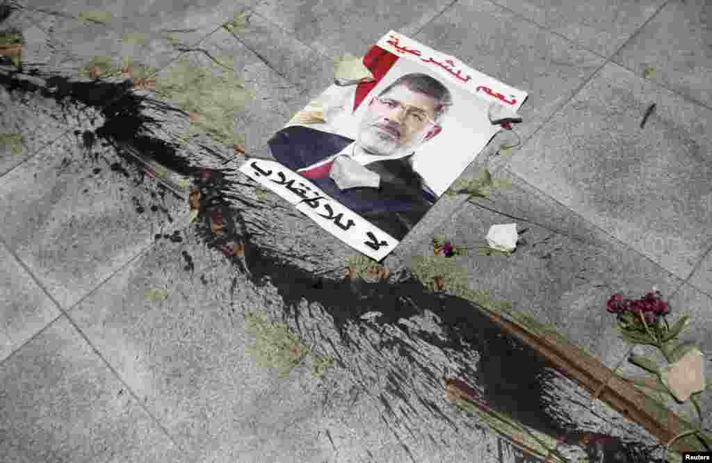 The blood from supporters of deposed Egyptian President Muhammad Morsi, killed during late-night clashes, stain the floor near a poster of Morsi which reads, &quot;Yes to legitimacy, no to the coup.&quot; The United States urged Egypt to pull &quot;back from the brink&quot; after security forces killed dozens of protesters. (Reuters/Amr Abdallah Dalsh)