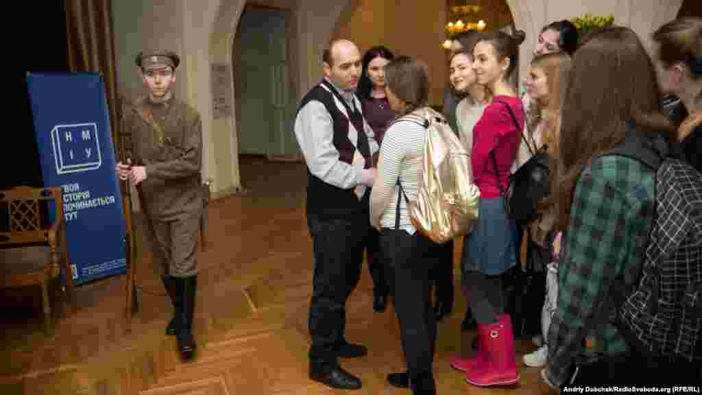 Студенти, які прийшли на відкриття виставки, слухають розповідь про військові однострої часів УНР