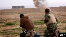 مقاتلان من قوات البيشمركه في معركة مع مسلحي "داعش" قرب سنجار