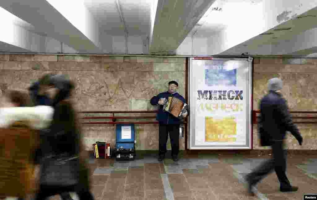 Чалавек сьпявае і грае на акардэоне ў падземным пераходзе ў цэнтры Менску, 17 сьнежня 2015.
