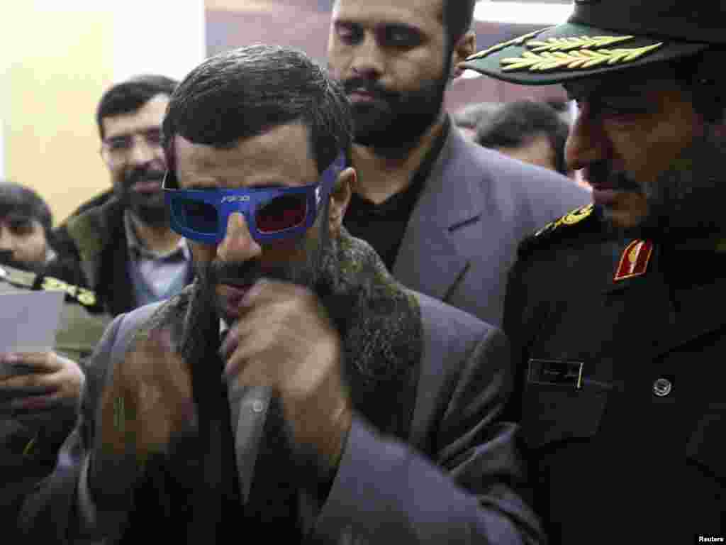 Iranian President Mahmud Ahmadinejad wears 3-D glasses to watch a program about an Iranian rocket during a visit to the control center for Iran's space program near Tehran February 4, 2008. Iran launched a rocket on Monday designed to send its first homemade research satellite into orbit in the next year, state television said, a move likely to add to Western concerns about Tehran's nuclear plans. REUTERS/Fars News 