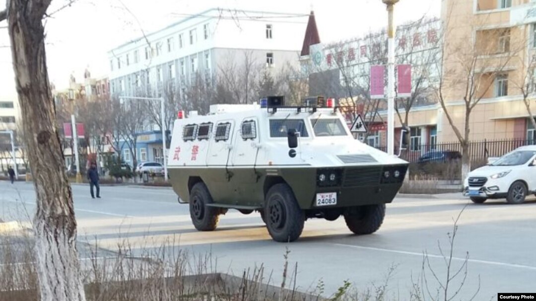 Военный автомобиль на улице населенного пункта в Синьцзяне.