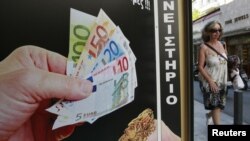 Афиныдағы ломбардтардың бірінің жанынан өтіп бара жатқан әйел. (Көрнекі сурет)