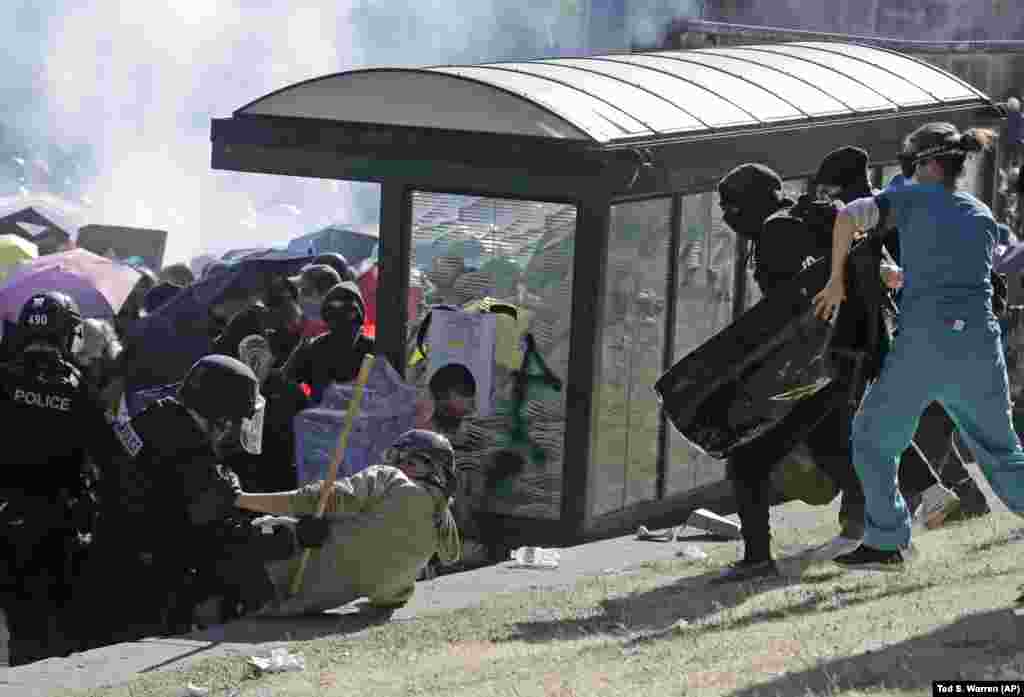 A nurse, right, who was providing volunteer medical care to protesters, moves in to come to the aid of a person, center-left, who was knocked down by police, Saturday, July 25, 2020, in Seattle as police clashed with protesters during a protest in support of Black Lives Matter and against police brutality and racial injustice at Seattle Central College in Seattle&#39;s Capitol Hill neighborhood. (AP Photo/Ted S. Warren)