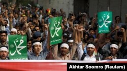 Supporters of Jamiat Talaba Islam, the student wing of religious political party Jamaat-e-Islami, hold signs as they chant slogans after the Supreme Court overturned the conviction of a Christian woman sentenced to death for blasphemy.