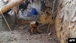 FILE: A child sifts through rubble at a destroyed religious seminary belonging to the Haqqani network after a U.S. drone strike in the Hangu district of Khyber Pakhtunkhwa province in November 21. The regions borders Kurram.