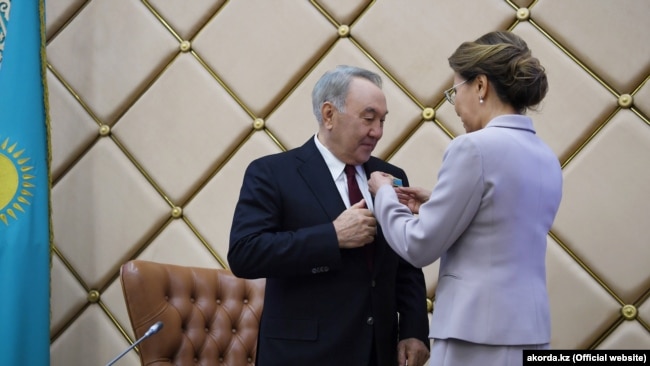 Спикер сената Казахстана Дарига Назарбаева вручает своему отцу экс-президенту Нурсултану Назарбаеву нагрудный знак «почетного сенатора». Нур-Султан, 6 июня 2019 года.