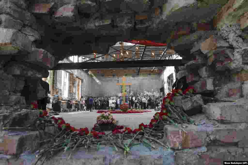 Flowers are laid in a hole in a wall as people gather in the gym of a school, the scene of the hostage crisis, in memory of victims on the 15th anniversary of the tragedy in Beslan, southern Russia, on September 1.&nbsp;(AP/Musa Sadulayev)