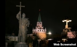 Православные храмы в кремлевских стенах выглядят не так навязчиво, как гигантский монумент тески Путина на первом плане в первом кадре