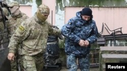 Заарештованого українського моряка (праворуч) ведуть на суд. Окупований Сімферополь, 27 листопада 2018 року