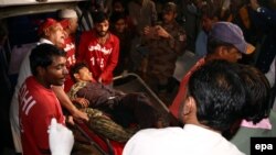 Медики несуть пораненого внаслідок вибуху бомби в храмі, Пакистан, 12 листопада 2016 року
