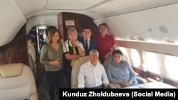 Бывший президент Кыргызстана Алмазбек Атамбаев (сидит слева) со своими сторонниками перед вылетом в Россию. 24 июля 2019 года.