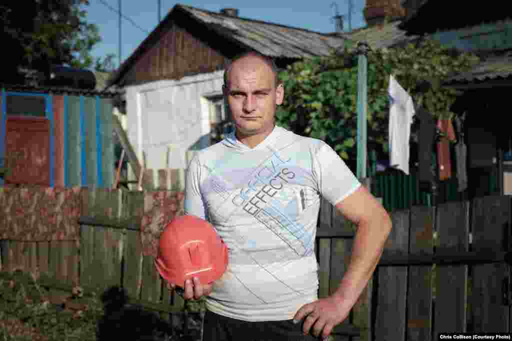 Sergei Dorokh stands with his mining helmet outside his home in the economically depressed neighborhood of Starayakolona in Myrnohrad. Dorokh worked in mining for five years before getting a job as a rescue worker at a local emergency service, responding to accidents at mining facilities in the region. The World Bank and other critics say Ukrainian mines have obsolete equipment and dangerous working environments.