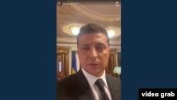 Террорист талаптарының бірін орындап, видеоүндеу жазып жатқан президент Владимир Зеленский. 