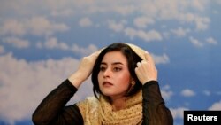 Shamela Rasooli, 22, Afghan presenter, adjusts her headscarf as she records her morning TV program at the Zan TV station (women's TV) in Kabul, Afghanistan May 8, 2017.