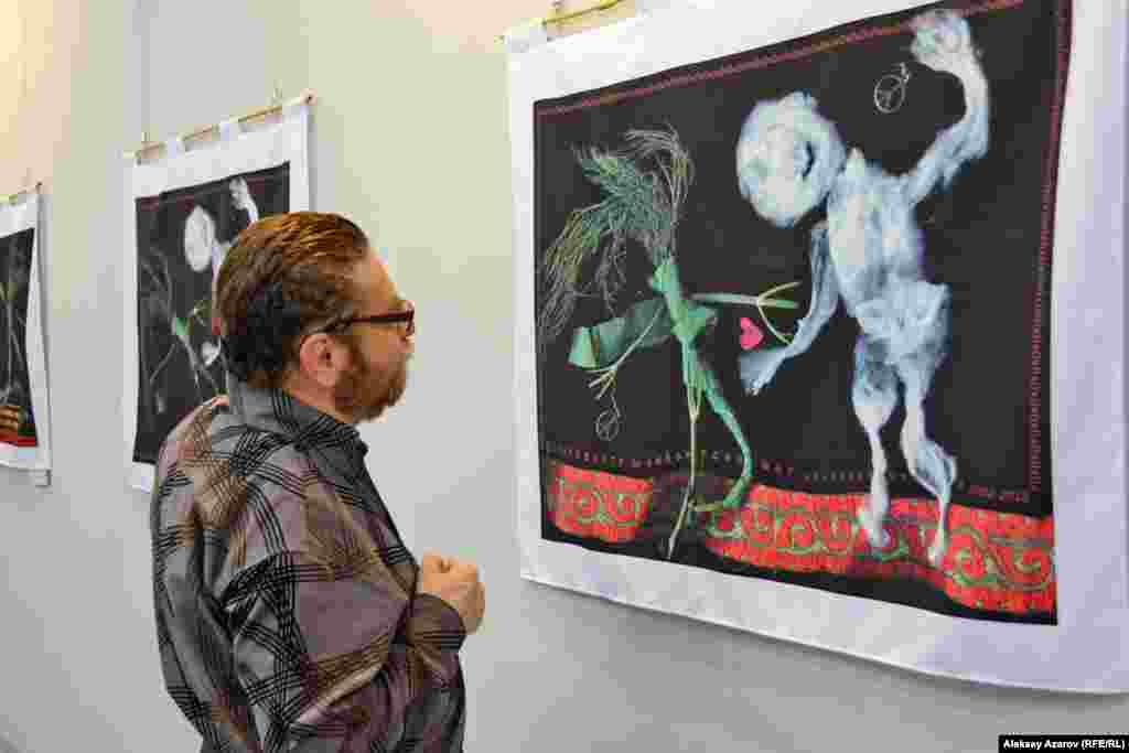 Зитта Султанбаева на этой выставке представила новые работы из карнавальной серии &laquo;Укропы и Ваты&raquo;. Правозащитник и журналист Андрей Свиридов рассматривает одну из работ этой серии.