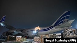 Munkások rakodnak ki egy amerikai katonai szállítmányt a kijevi Boriszpil repülőtéren 2022. január 25-én. A raklapokon Javelin tankelhárító rakéták nyugszanak
