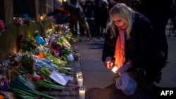 A woman outside the main Synagogue in Copenhagen lights a candle to honor those killed by a gunman on February 14.