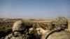 American troops look out toward the border with Turkey from a small outpost near the town of Manbij, northern Syria, Wednesday, Feb. 7, 2018