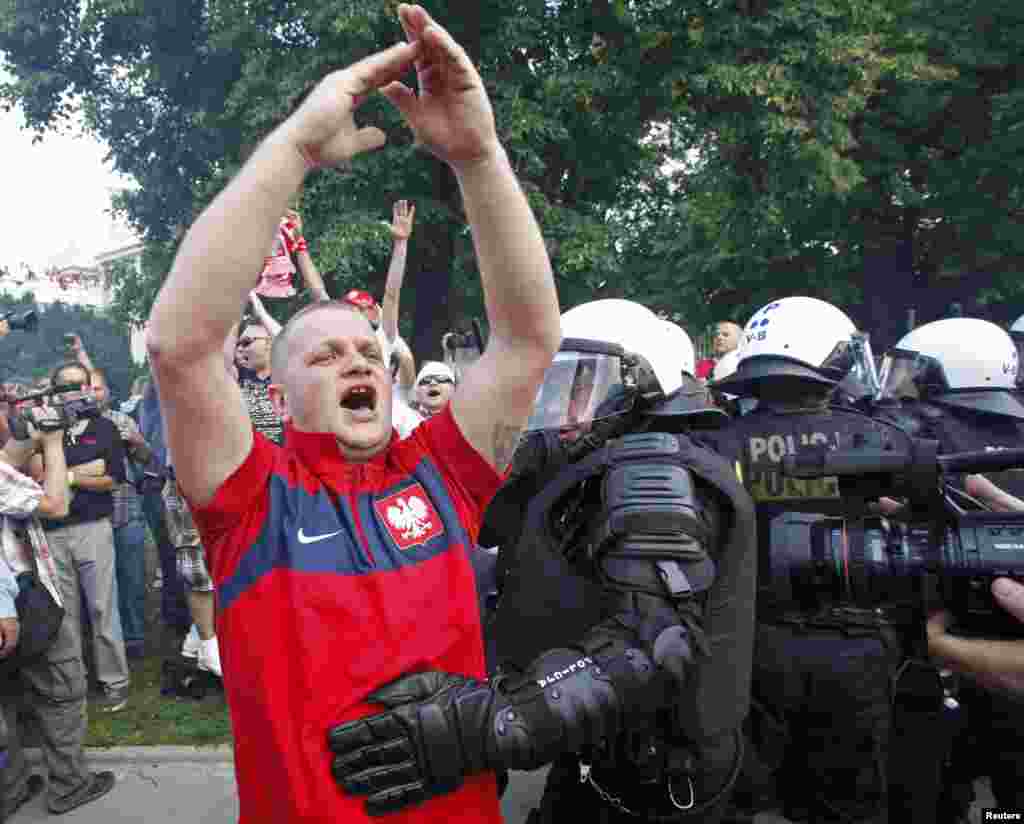 A Polish soccer fan is moved by riot police protecting Russian fans marching to the National Stadium in Warsaw.