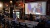 Staff and customers of a Moscow bar watch Russian President Vladimir Putin address the nation on state television on March 25. 