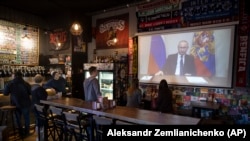 Osoblje i gosti u moskovskom baru gledaju obraćanje ruskog predsednika Vladimira Putina, 25. mart