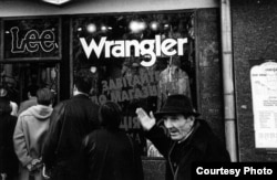 A man in Kyiv reacts as people line up outside a shop selling American jeans.